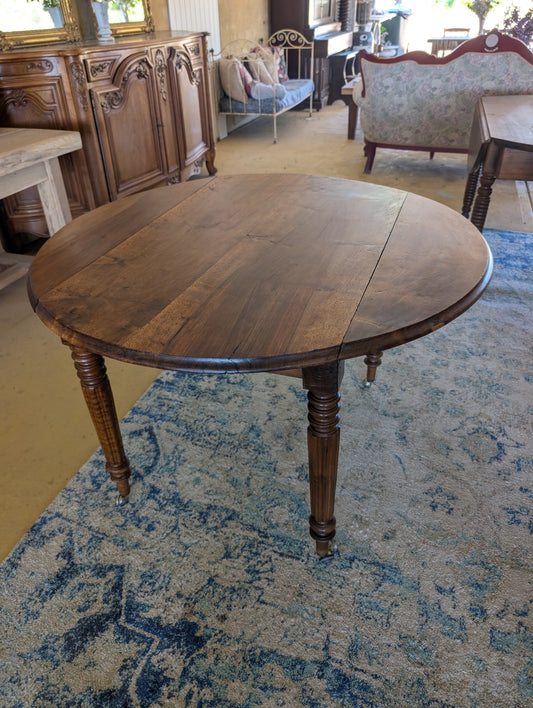 19th C. French walnut round table with fold down sides and turned legs on castors.
