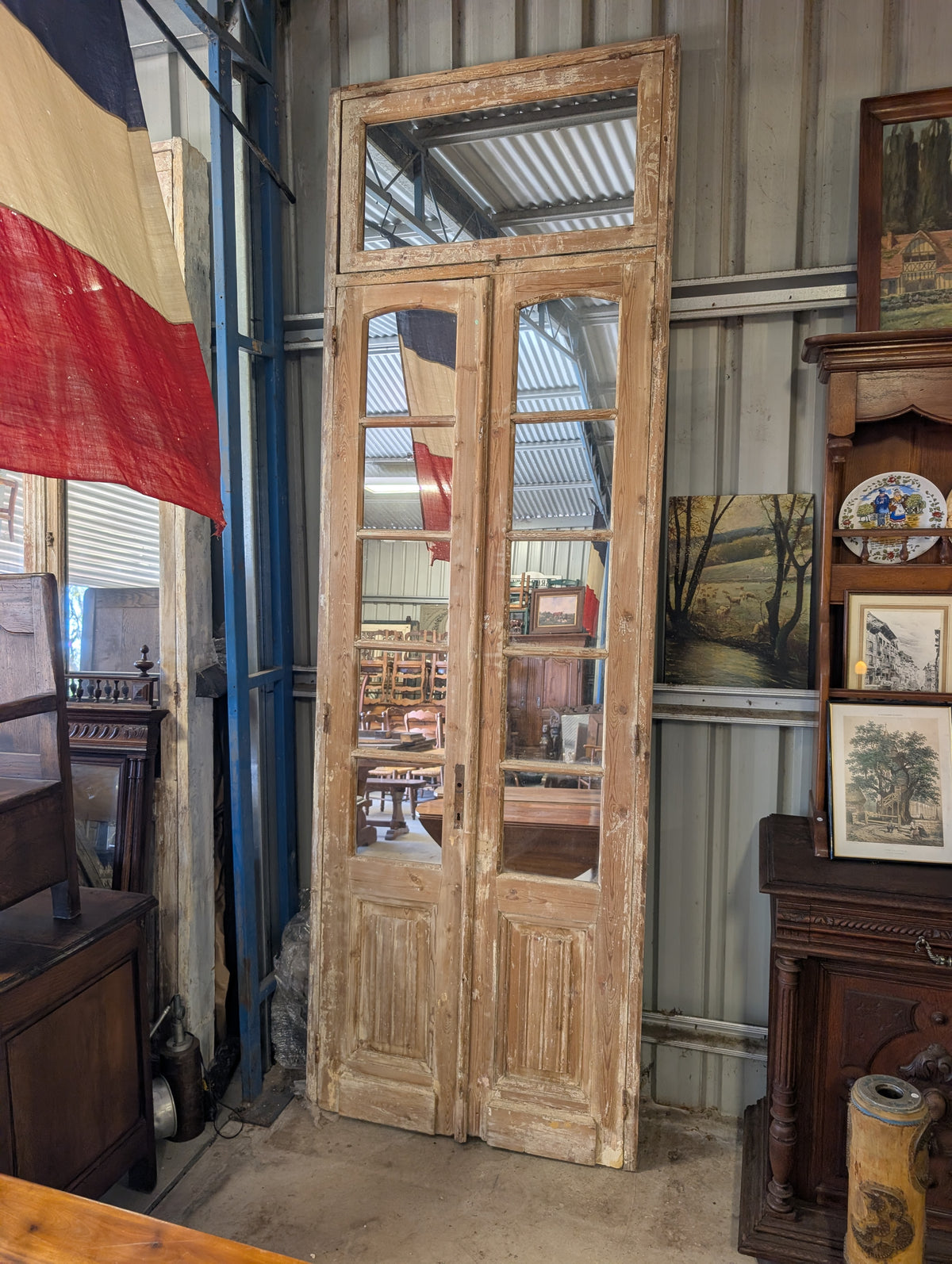 French antique French double doors with a matching top transom door with mirrors in.