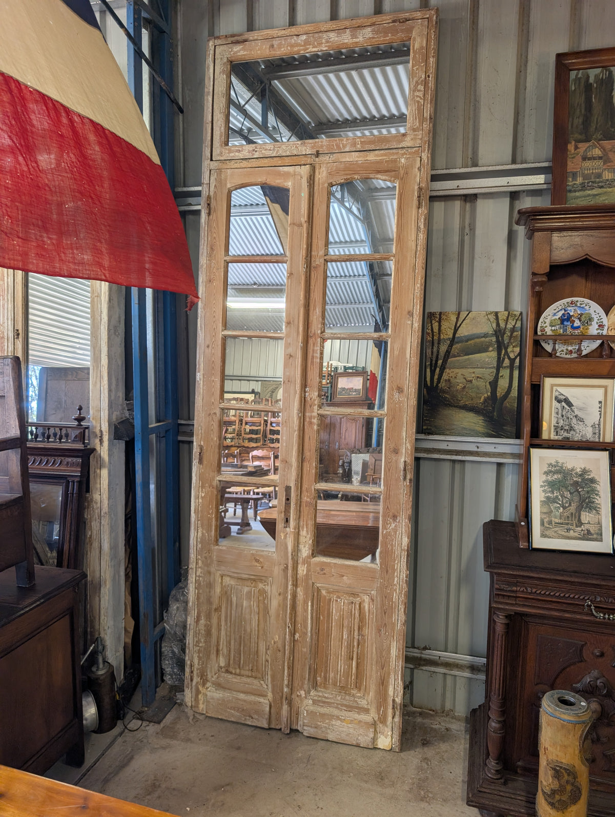 French antique French double doors with a matching top transom door with mirrors in.