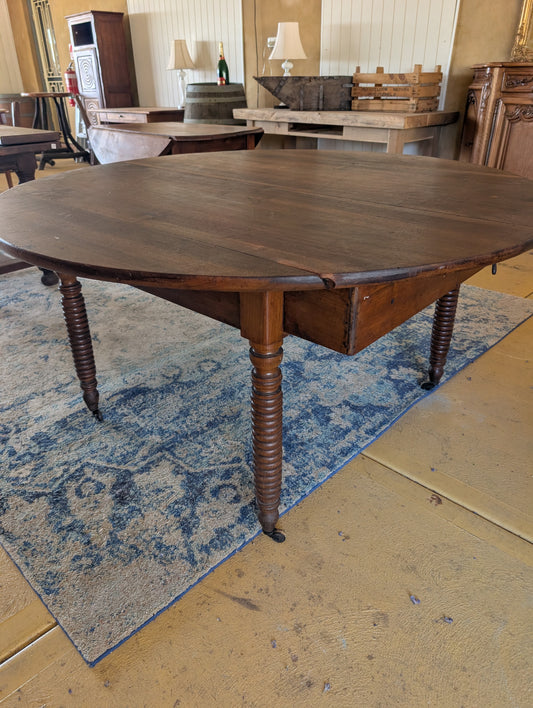 19th C. French walnut round table with fold down sides & turned legs.